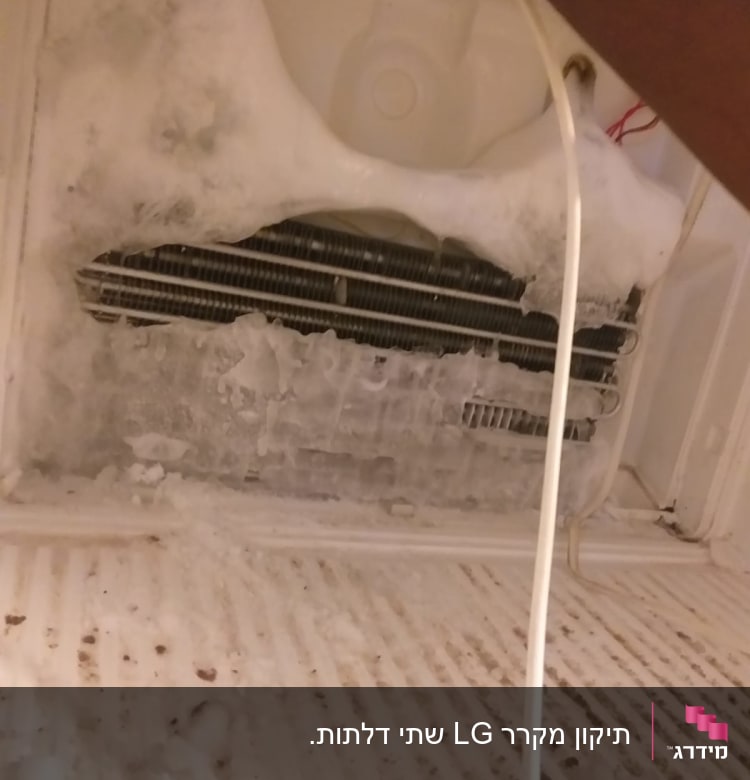 מקפיא עם קרח מצטבר על סלילים, יד מחזיקה כבל